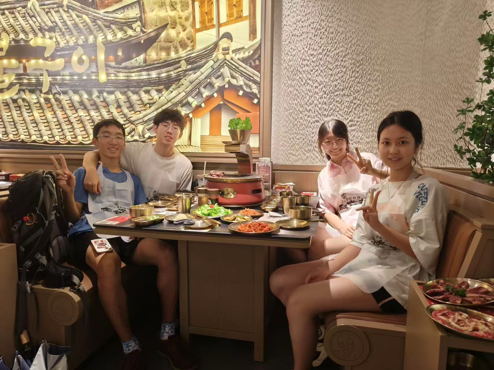 四个人围坐在西塔老太太的烤肉桌旁合影