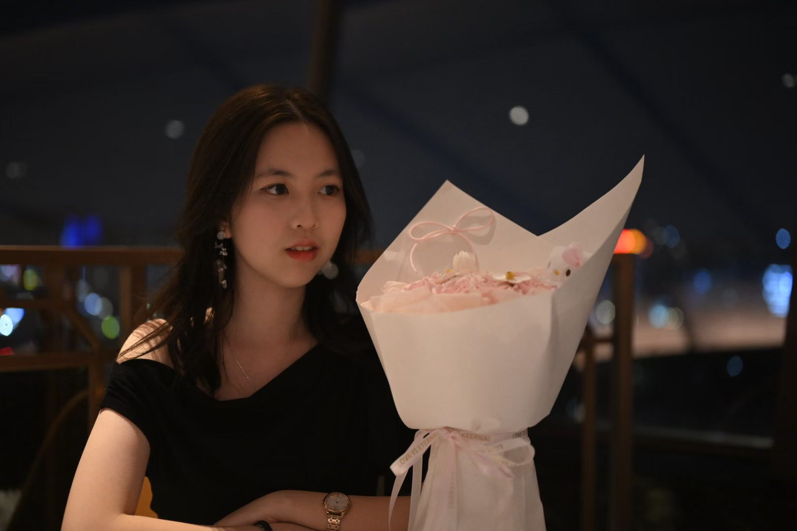 Crystal 与一束浅粉色的花合影